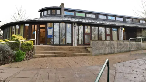     Suffolk Primary Care Haven Health doctors surgery in Felixstowe, it shows a curved building with lots of windows, steps and a ramp to the building 