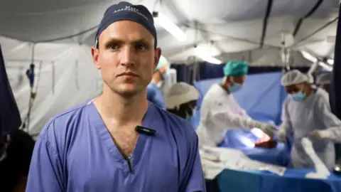 Foreign Office Matthew Newport in blue surgical scrubs