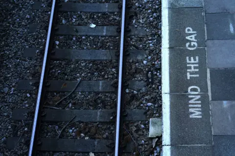 PA Media A "mind the gap" sign on a platform