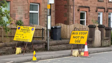 An image of a road. A sign states "bus stop not in use"