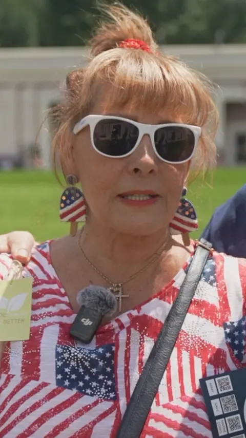 A woman in a shirt with American flag pattern.