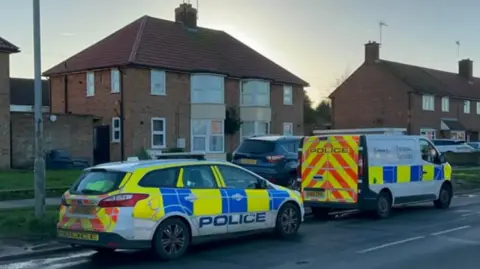 Ben Parker/BBC Two police cars parked outside a home in Ipswich
