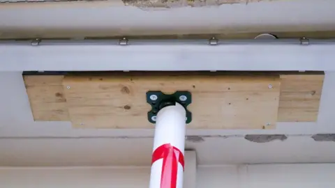 A close up of a prop attached to wooden plank, attached to a ceiling in a hospital