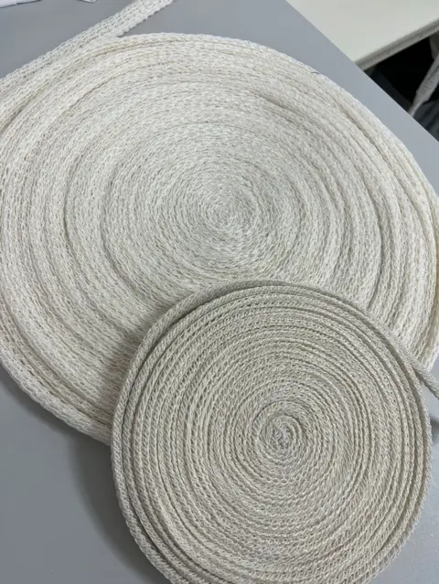Heriot-Watt University Two rolls of meat netting, one smaller one on top of another. They are off-white in colour and rolled up tightly in two coils