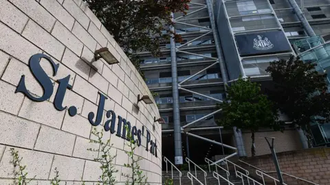 St James' Park in Newcastle. The name of the grounds is on a wall, while the club's logo is displayed on the stadium.