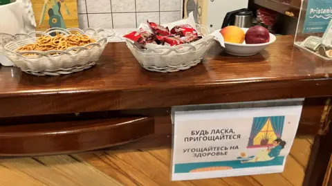 A sign in Ukrainian and Russian at the Pristaniste cafe invites residents to help themselves to a snack