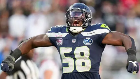 Derick Hall pumps his arms as he celebrates during the Super Bowl