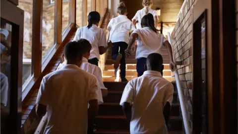 Getty Images School childern running up stairs in school