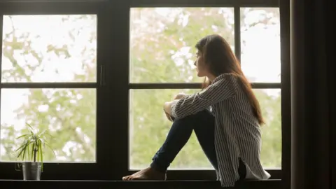 Getty Images Woman looking out of window