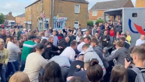 Tom Percival/BBC People play-fighting at Rowell Fair
