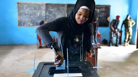 AFP A woman casts her vote in a ballot box at the polling station in Freetown on March 31, 2018 during the second round of Sierra Leone's presidential election