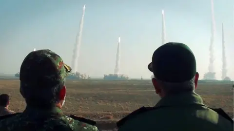 EPA Handout photo shows Iranian Islamic Revolution Guard Corps (IRGC) chief Hossein Salami (R) watching missiles launch during an exercise in Iran (15 January 2021)