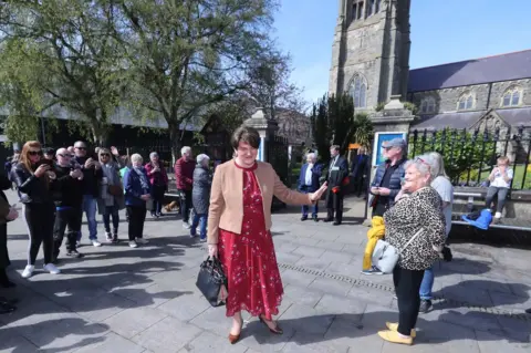 PA Media Arlene Foster speaks to well-wishers after a church service in Coleraine