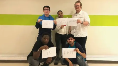 A group of college students holding pieces of paper with their favourite slang words