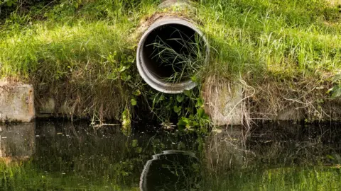 Getty Images Sewage pipe at river