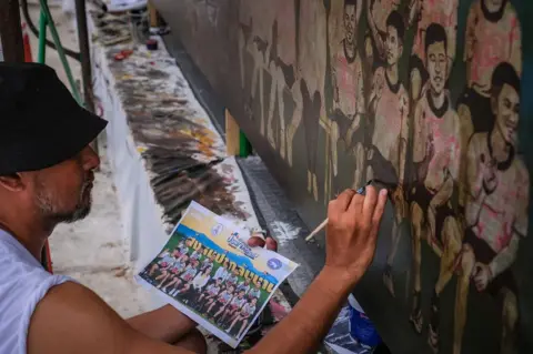 Getty Images Artists work on an art mural at Art Bridge gallery in Chiang Rai, Thailand