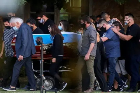 Reuters Friends and family carry the casket of soccer legend Diego Armando Maradona, at the cemetery in Buenos Aires, Argentina, November 26, 2020.