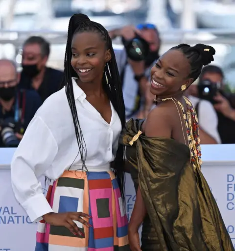 Getty Images Two women smile and pose on the red carpet.