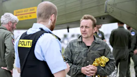 AFP Peter Madsen talks to a police officer in Dragoer Harbor south of Copenhagen on August 11, 2017