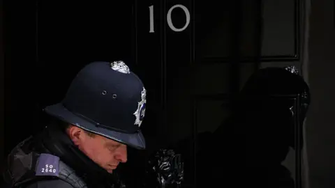 Getty Images A police officer leaves number 10, Downing Street in London, England