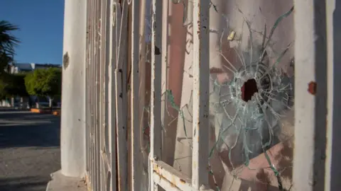 Getty Images A bullet hole on the window of a house in El Aguaje, Aguililla municipality, Michoacán state, Mexico, on 9 February.