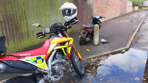 TVP Roads Policing A police motorcycle next to a moped on a residential street.