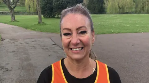 Jonathan Park/BBC Leigh Betts in a running top in park