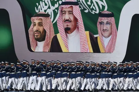 AFP Newly graduated Saudi air force officers march in front of a banner bearing portraits of King Salman (C), then Crown Prince Mohammed bin Nayef (R), and then deputy Crown Prince Mohammed bin Salman at King Salman airbase in Riyadh on 25 January 2017