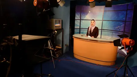 AFP File photo: In this photograph taken on January 30, 2013 a female Afghan news presenter reads the news at a studio in Kabul.