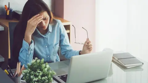 Getty Images Stressed woman at computer