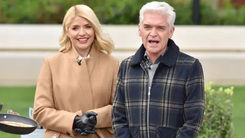 Getty Images Holly Willoughby and Phillip Schofield with Ainsley Harriott attempt a world record for tossing pancakes during the This Morning show. on February 25, 2020 in London, England