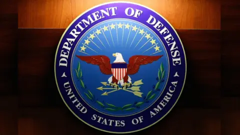 Getty Images A light shines on the seal of the Department of Defense
