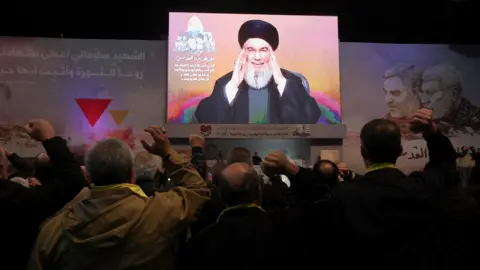 Reuters Hezbollah leader Hassan Nasrallah addresses supporters via video link in Beirut's southern suburbs, Lebanon (3 January 2024)