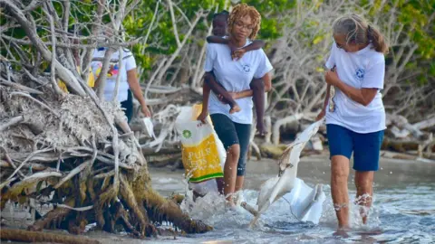 Courtesy Jennifer Meranto Jennifer Meranto (right) and volunteers collect marine debris