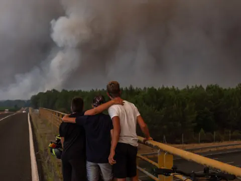 NurPhoto/Shutterstock Forest fire around the town of Hostens, France, on August 10, 2022. Many villages were evacuated, such as Saint-Magne, Mano, Belin-Beliet, Moustey and Saugnac-et-Muret, and the A63 highway were also closed.