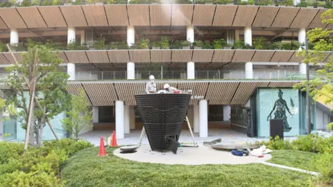 Getty Images Workers install the cauldron of the 1964 Tokyo Olympic Games at the National Stadium on June 17, 2020 in Tokyo