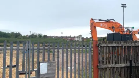 A digger at the edge of the site