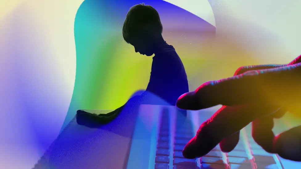 BBC Artistic image showing the shadow of a small child in the background and an adult's hand on a computer keyboard in the foreground.