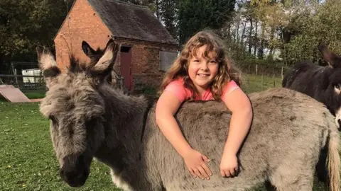 Amanda Ball Honey with a donkey at the sanctuary