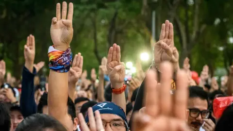 AFP Participants gesture a three-finger salute at the start of a "run against dictatorship" in Bangkok