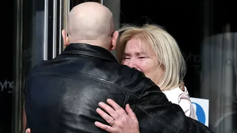 Getty Images Kate Nash, whose 19-year-old brother William was shot dead, was comforted by campaigner Eamonn McCann