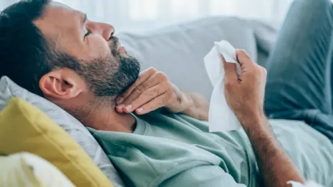 Getty Images Man with Covid and a sore throat