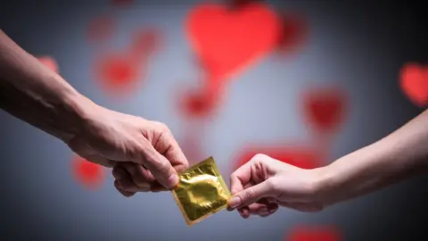 Getty Images Pair holding a condom