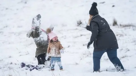 PA Families having snowball fights on the mountains at Brecon Beacons National Park, Wales