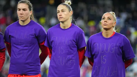 Canada's women's players wear purple T-shirts with the phrase 'enough is enough' on to protest against their national association before a SheBelieves Cup match