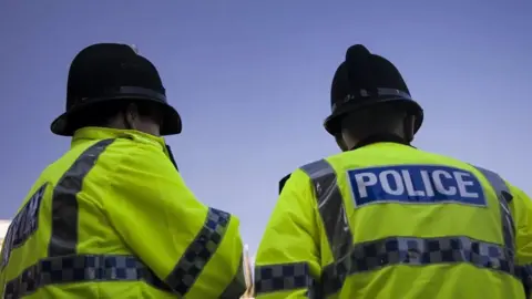 Getty Images Two police officers in uniform with back to camera