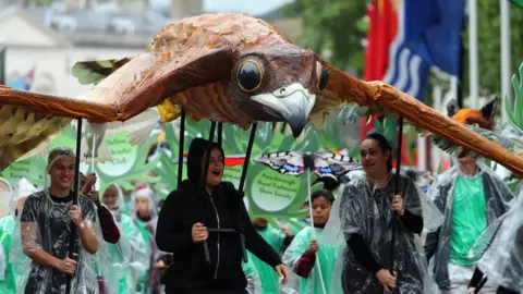 Getty Images A parade travels down The Mall during The Patron's Lunch held for The Queen's 90th birthday