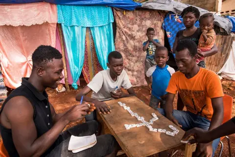 Orlando Barria / EPA People play dominoes