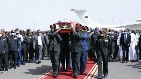 Getty Images Coffin of Sudan's Defence Minister Gamal Omer, 59, died in Juba, the capital of neighboring South Sudan, is being carried during the official funeral ceremony at Khartoum International Airport on March 25, 2020 in Khartoum, Sudan.