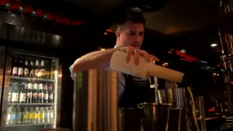 A barman pours a cocktail in a Newcastle city centre bar